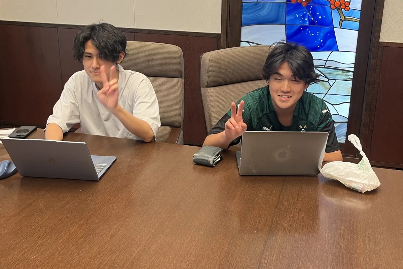 ノートPCで開発しながらピースする2人