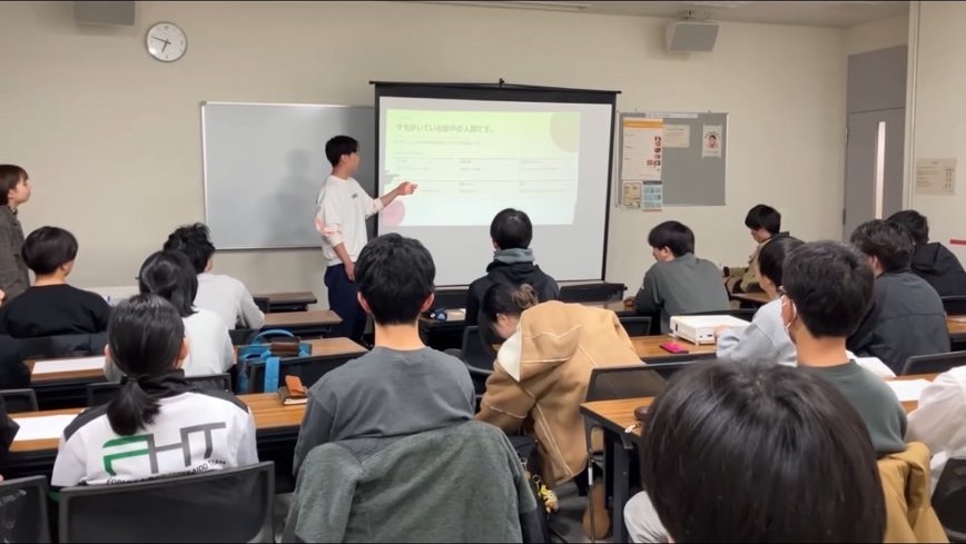 スクリーンの前で発表する様子